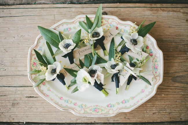Honey & Poppies created simple, modern boutonnieres with white anemones and olive leaves for Brendon and his groomsmen to wear with their classic black suits. For a subtle hit of color and to tie in with the wedding’s palette, the boutonnieres were accented with short lengths of navy ribbon.