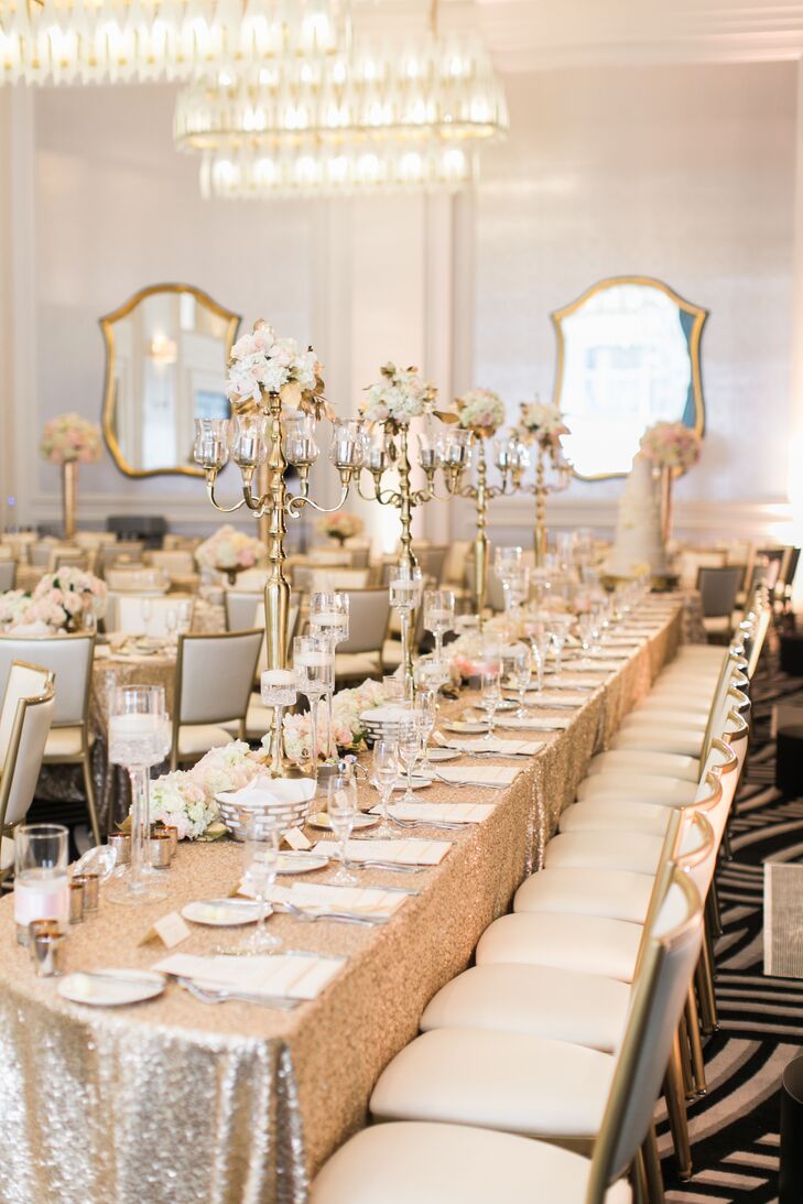 The bridal party's reception table featured four gold candelabras with small floral arrangements atop. Glass vases were filled with floating candles.