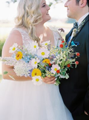 Couple Poses While Holding a Bouquet of Colorful Wildflowers