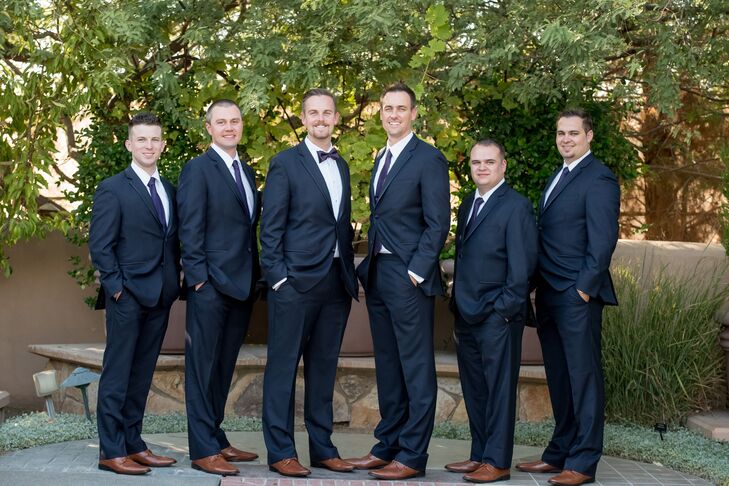 Brett wore a dark blue tux without the vest, as did the rest of the groomsmen. Brett stood out by donning a dark purple bow tie, while the groomsmen wore regular dark purple ties.