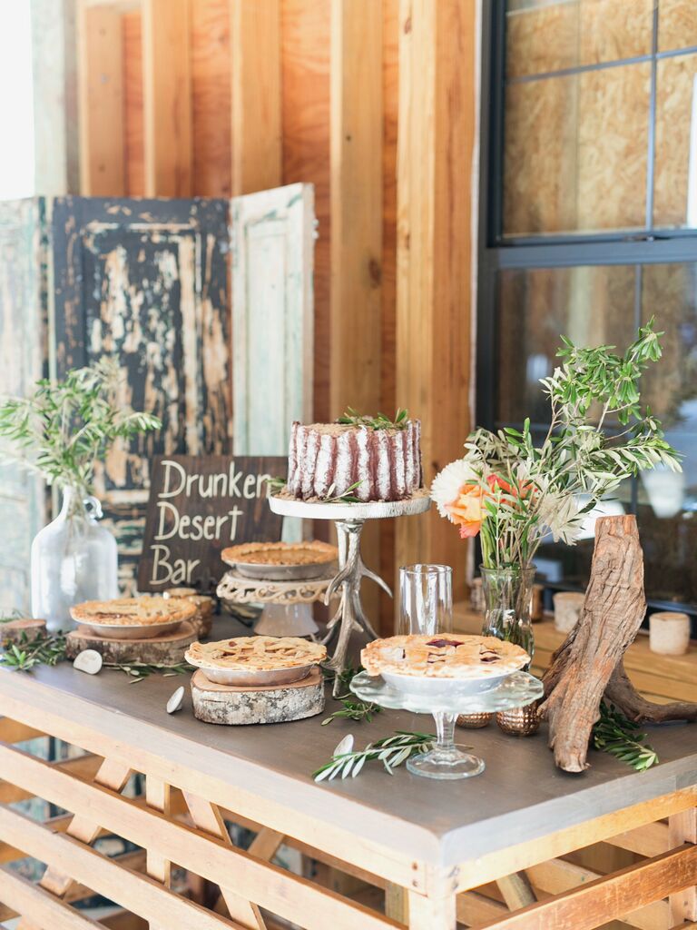 rustic wedding dessert table with pies, naked cake and greenery arrangements