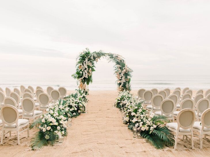 Beach Ceremony Site with Wedding Arch, Tropical Flowers and Palm Leaves