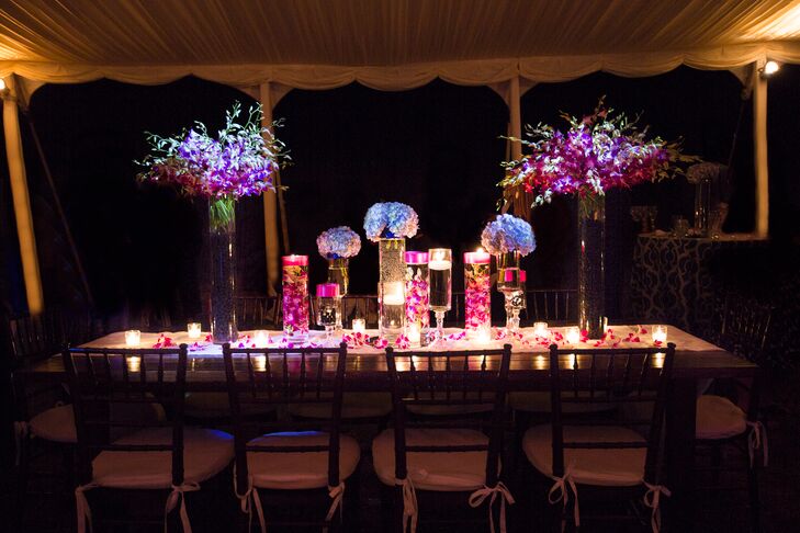 Picking flowers was the hardest part of wedding planning for Liz because she didn't know much about them. "I knew I wanted my colors to stand out and I loved the look of submerged flowers—from there, I left it up to the florist." says Liz. "She even incorporated fresh raspberries and blue berries into the bases of the tall vases!" rnrn