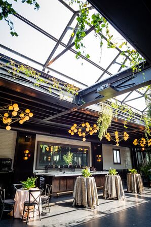 Industrial Cocktail Space With Hanging Greenery, Chandeliers, Skylight and Tables