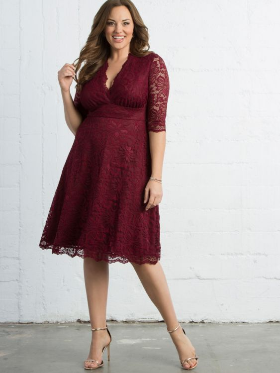 A model wears this knee-length lacy gown with a V-neck and three-quarter sleeves.