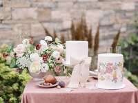 wedding cake table with two white fondant cakes and flower centerpiece 