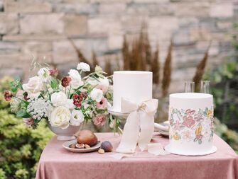 wedding cake table with two white fondant cakes and flower centerpiece 