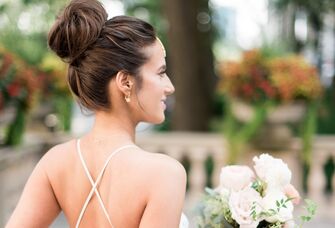 Bride wears her hair in an elegant top knot. 
