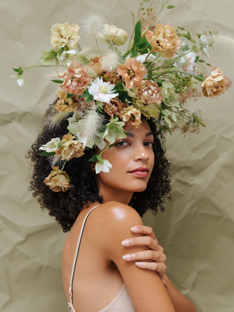 A model wears this stunning floral arrangement as a wedding headpiece or fascinator
