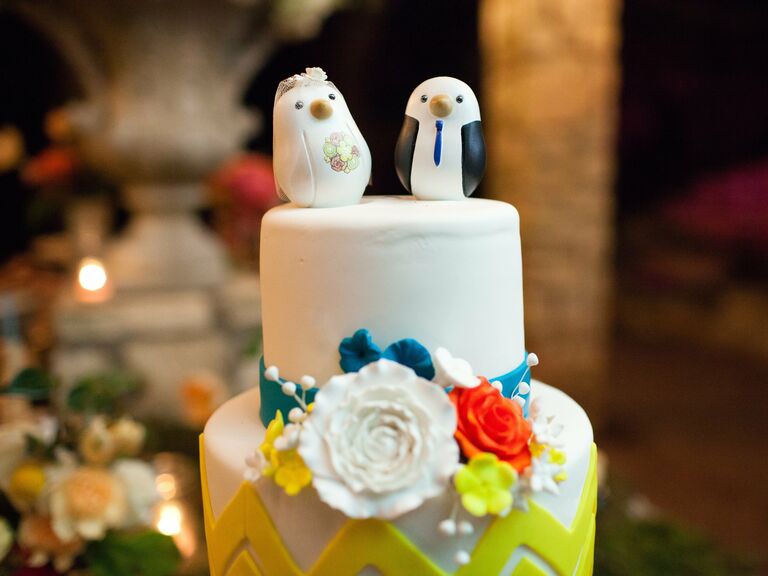 Cute animal wedding toppers of bride and groom penguins.
