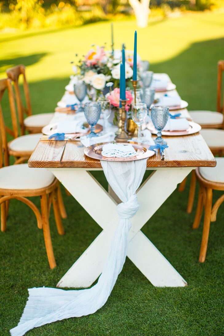 Rustic wooden farm tables and cross-back chairs were arranged in a mango field for the newlyweds' dinner reception at Flora Farm in San Jose del Cabo, Mexico.