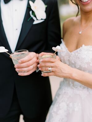Bride and Groom Hold Cocktails With White Hat Drink Stirrers