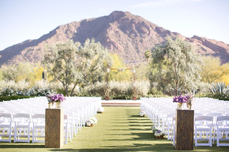 The celebrations kicked off with a ceremony on the Casa Paloma Event Lawn, where the couple exchanged vows with Camelback Mountain and the surrounding valley providing a breathtaking backdrop for the event. “When Aaron and I were first looking at locations, there weren’t any places that we both agreed on,” says Kathleen. “It wasn’t until we were driving home from looking at venues that we stopped at El Chorro. I had read about the venue online, but did not write it down as an option. I had no idea that they had so much extra land and venue options on their property. When we stopped by and looked around, we both knew instantly that we wanted to get married there.” For the ceremony, the pair kept the decor to the minimum, so as not to detract from the beautiful natural scenery. Pillars boasted bright purple lilacs and lavender stood at the entrance of the aisle and a few moss-covered planter boxes filled with lush white blooms were placed at the ends of intermittent rows.