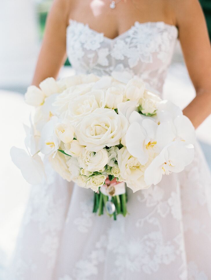 Bride Holds Structured Bouquet of While Garden Roses, Orchids and More