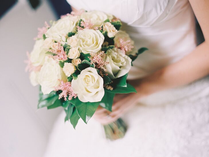 A beautiful arrangement of traditional ivory roses, smaller garden roses and blush astilbe whisps filled Emily's bridal bouquet.