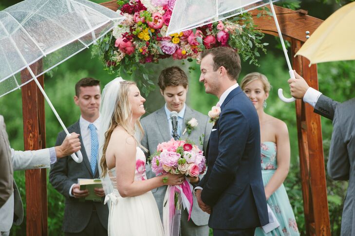 Lauren held onto her pink round bouquet filled with peonies, roses and ranunculus during the ceremony. Lauren's best friends and the ushers held clear umbrellas over their heads as it rained during the ceremony, but it stopped in time for Lauren and Brian to say their vows.