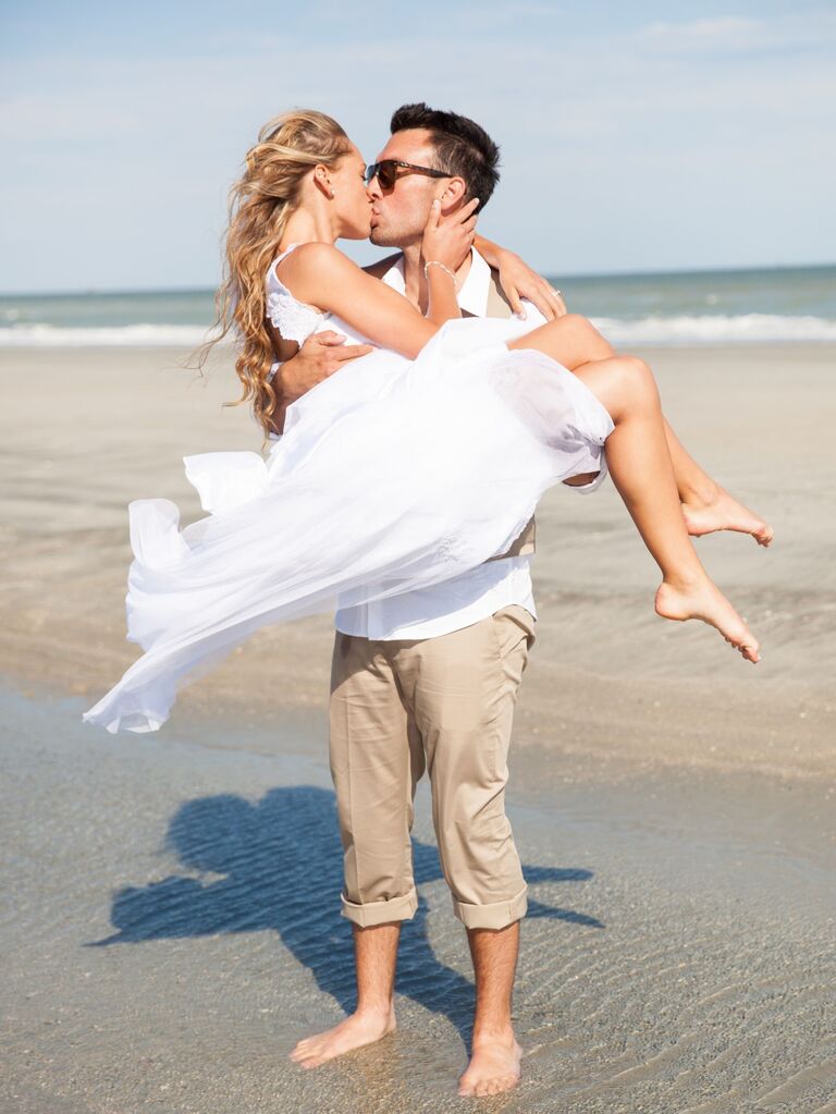 Couple kisses in a romantic moment on the beach. 