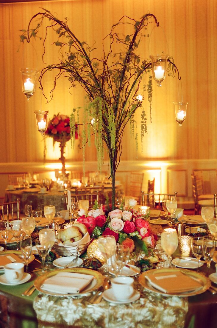 Tall tree-branch centerpieces give the tables a dreamy, romantic, forest-like atmosphere. Hanging tealight candles lend an ethereal feel.