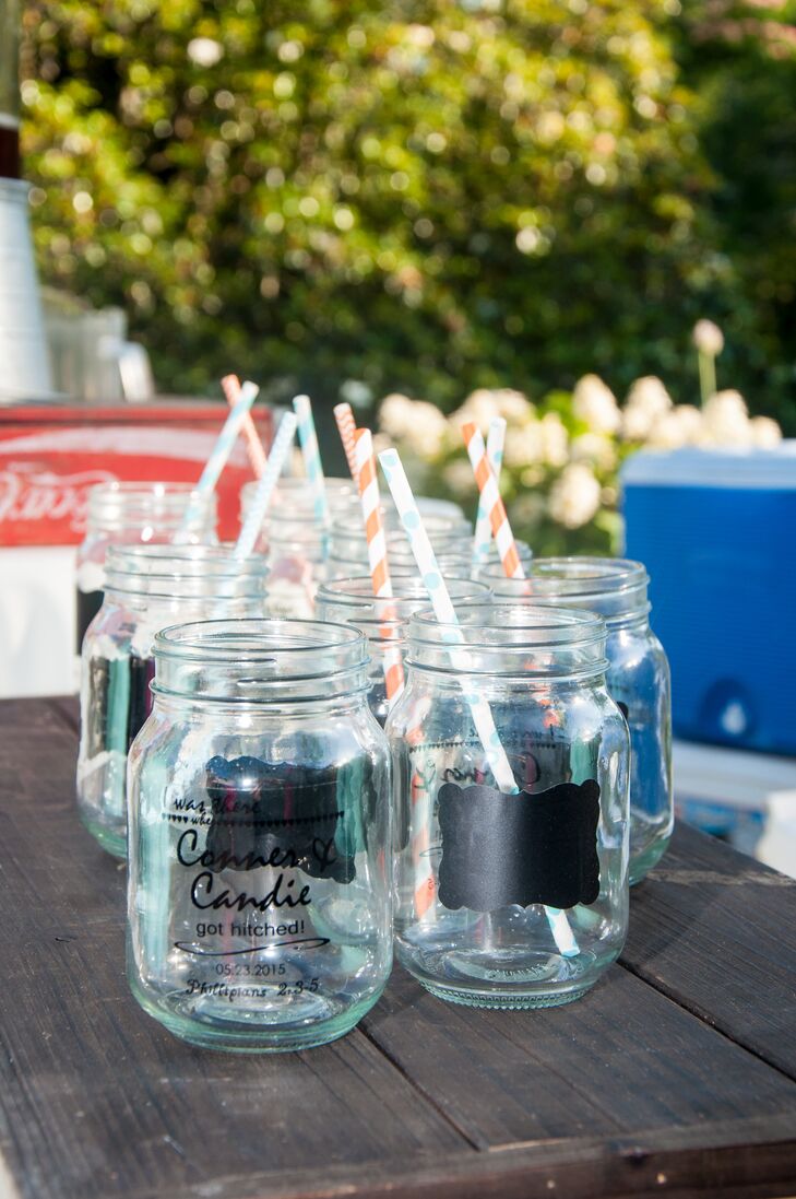 These mason jar cups were important to the reception design. Its blue tint inspired Candace and Conner to give her parents' home in Auburn, Alabama, a little antique flair, including vintage desks and a typewriter. The glasses also served as their wedding favors with a chalkboard accent so guests could label their gifts.