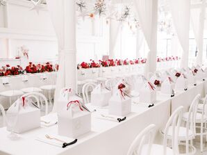 Long Farm Tables at All-White Rehearsal Dinner With Red Flowers and Gift Boxes