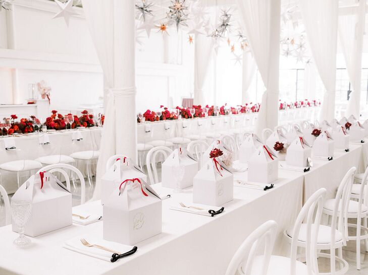 Long Farm Tables at All-White Rehearsal Dinner With Red Flowers and Gift Boxes