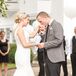 Anna and Tyler shared an intimate moment together while they were surrounded by their wedding party. Anna wore an ivory wedding dress with a trumpet-style silhouette and a V-neckline while Tyler wore a gray-and-white-patterned jacket with a black tie.