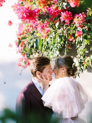 Bride in Pink Tulle Gown and Groom in Maroon Suit Jacket Kiss Under Hanging Bougainvillea