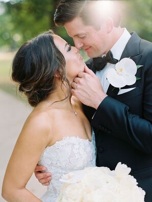 Bride in Sweetheart Dress and Low Bun Embraces Groom With Orchid Boutonniere