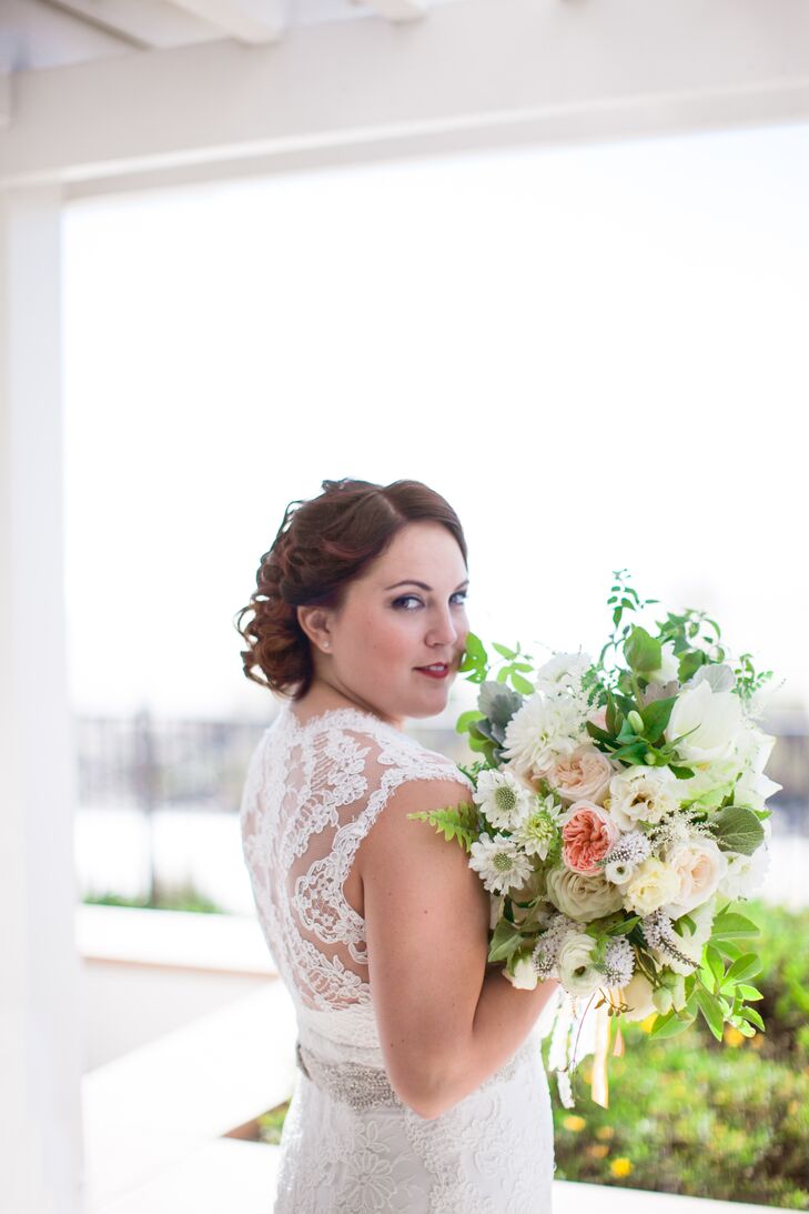 Bayley wore an ivory lace wedding dress accented with a crystal belt. She held a lush flower bouquet filled with scabiosa, garden roses, and dahlias accented with veronica and leaves.