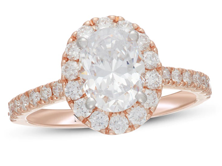Oval diamond center with round diamond rose gold halo on rose gold band with round diamonds