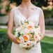 In tribute to her father, Adrienne included unripened blueberries in all of her wedding party bouquets. Her bridal bouquet also included pale orange peonies and white roses.