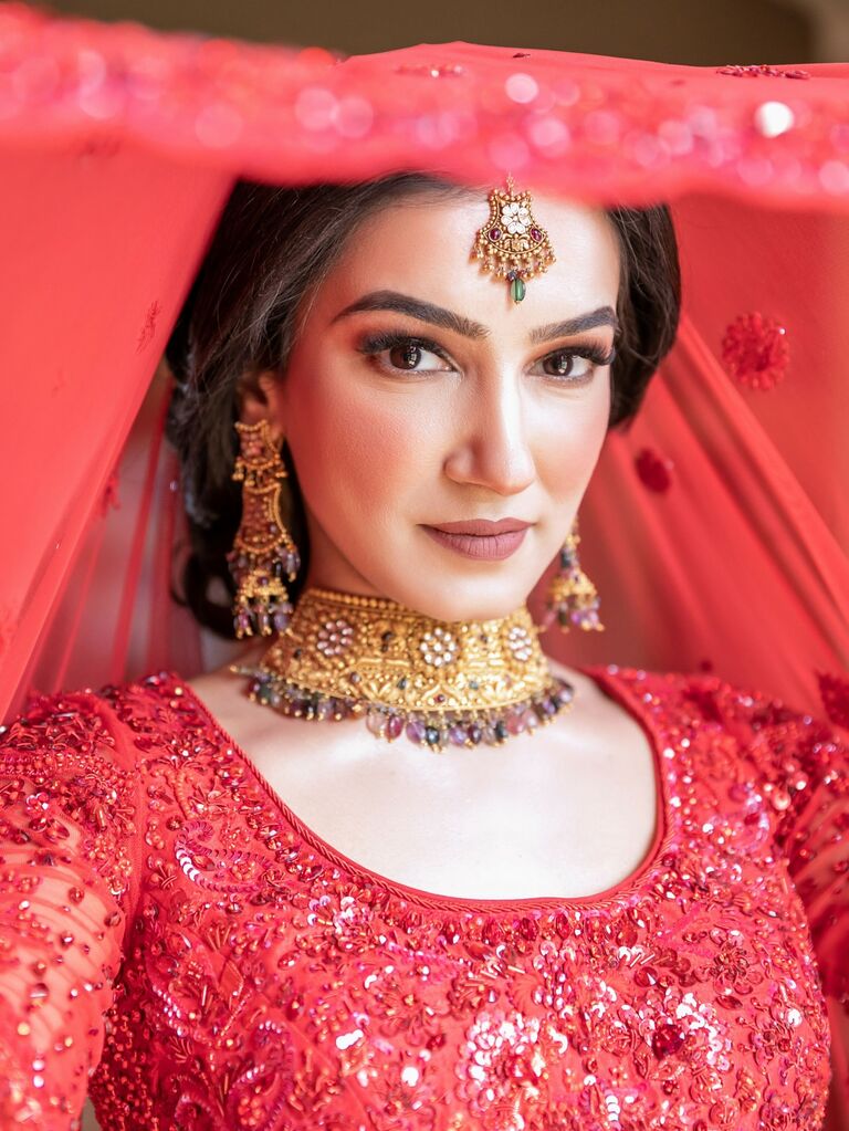 Indian bride wears a beautiful gold necklace and matching earrings. 