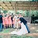 Samantha and Chris's wedding party dressed in styles reflective of the bride and groom. Chris's groomsmen wore their formal military blues or a tan suit and navy bow tie. Samantha's bridesmaids brought out her feminine, Southern side in one-shoulder coral dresses and cowboy boots.