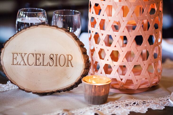 Molly and Boston named their reception tables with some of their favorite places, such as Excelsior and Calhoun. Each location were burned into unfinished wooden rounds, which matched the wooden farm tables and rustic lantern centerpieces.