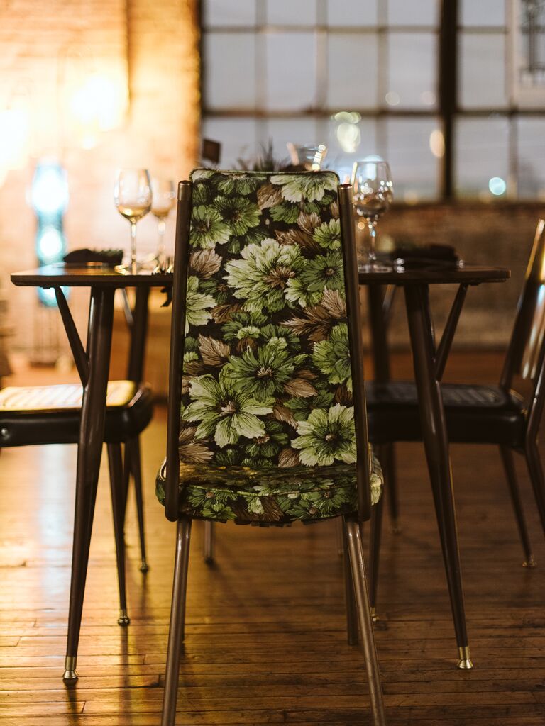 upholstered wedding chair at wooden table with green and brown floral print