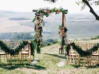 Altar at outdoor wedding ceremony with floral arch