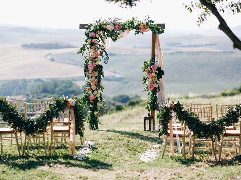 Altar at outdoor wedding ceremony with floral arch