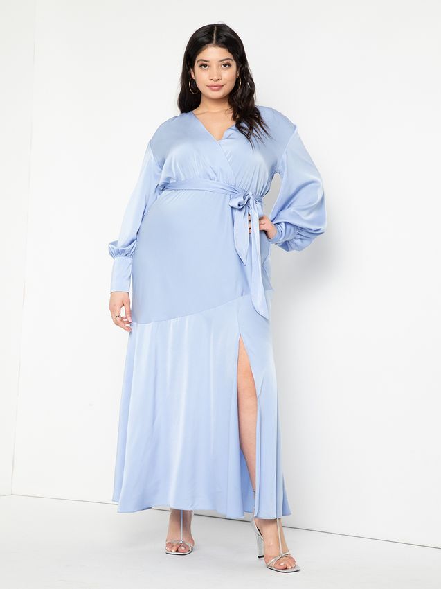 Model wears a soft blue gown with a belted waist and long, draping sleeves. 