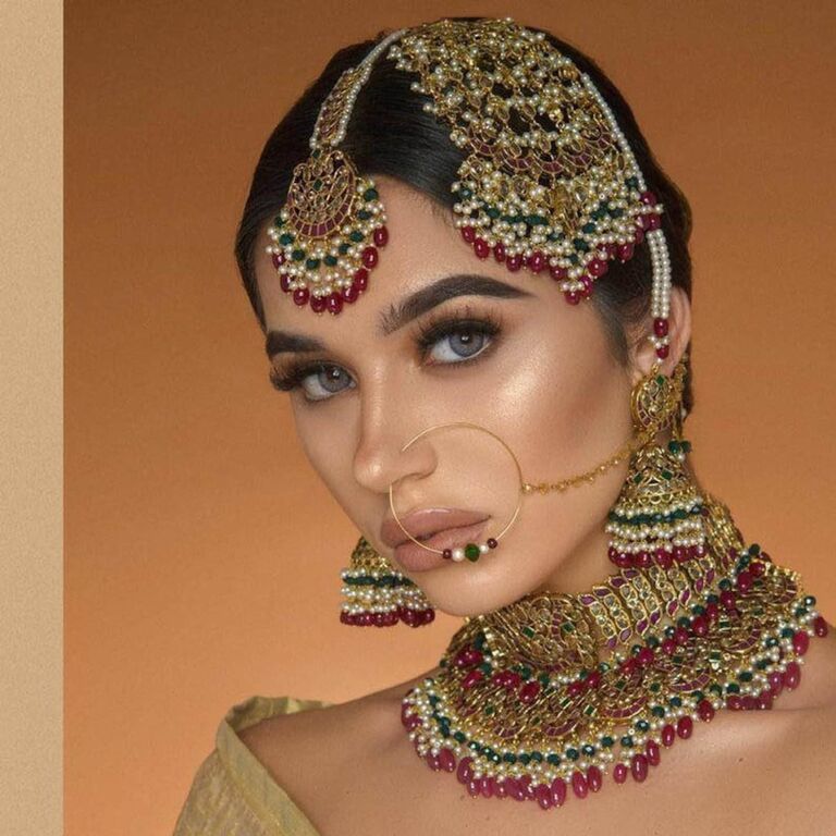 Model wears a colorful Indian jewelry set. 
