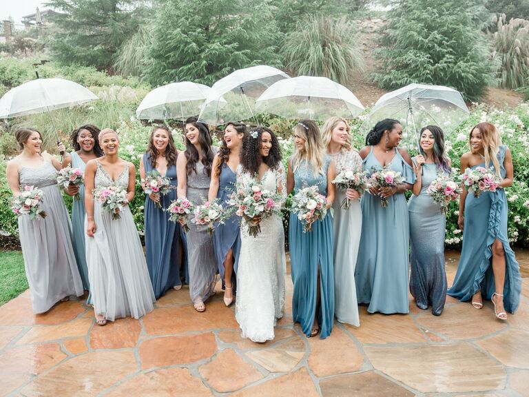Bridesmaids wear dresses in various shades of pale blue. 