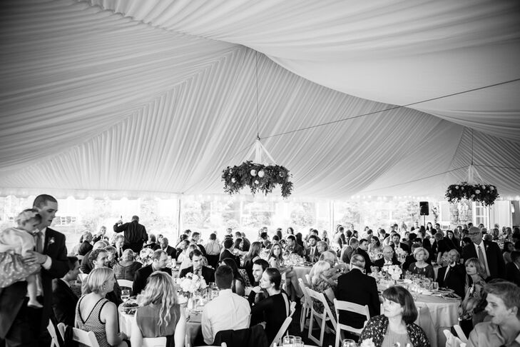 The reception took place under the white tent set up on the lawn at Alderbrook Resort and Spa in Union, Washington. Elegant chandeliers covered in leafy greens hung from the ceiling, bringing the surrounding landscape in for the celebration.