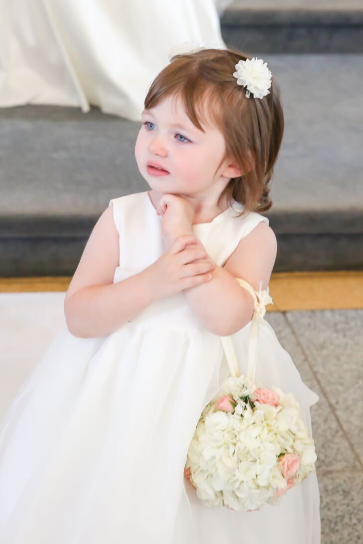 The couple's flower girl wore an ivory dress and carried a miniature pomander made from hydrangeas and roses for her walk down the aisle.
