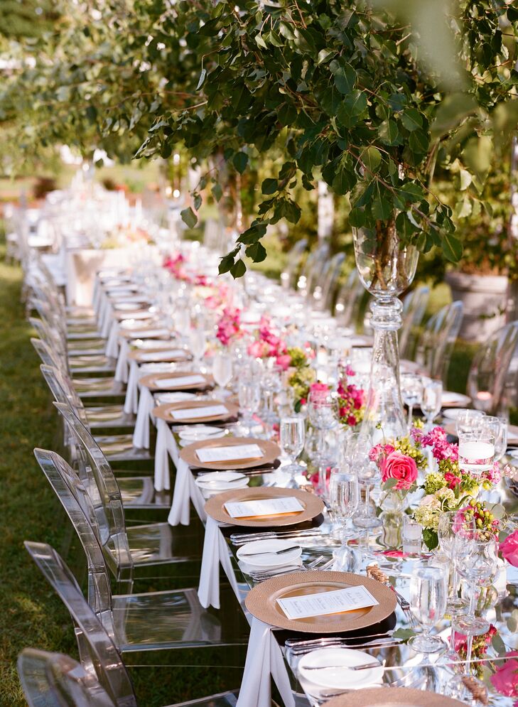 Long tables were decorated with hot-pink peonies, garden roses, stock and hypericum. Greenery hung from the tent frame along with chandeliers.