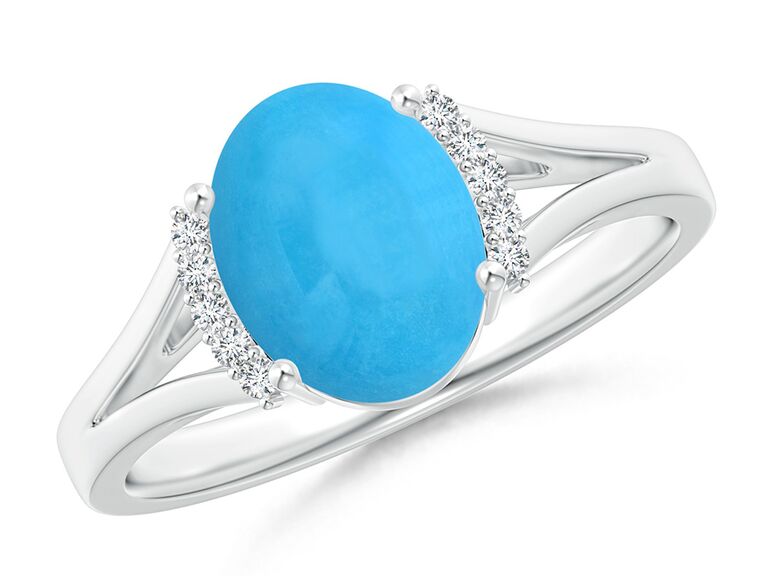 Oval turquoise gemstone bordered by diamonds on silver band