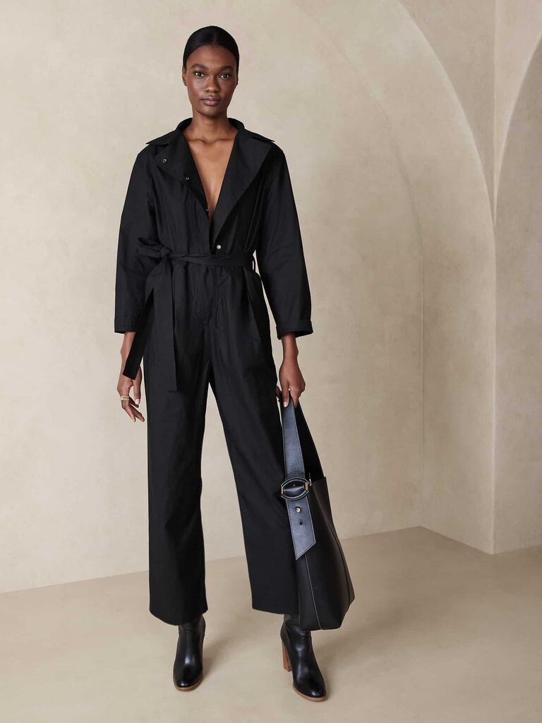 Model wearing black jumpsuit with buttons on the front, a waistbelt and long pants