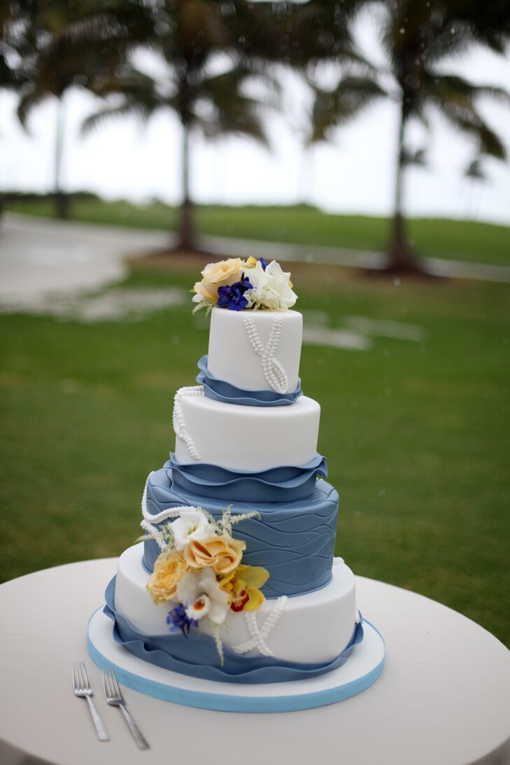 Baked by Kakes by Karen, the couple chose a four-tier blue and white confection composed of white champagne cake with raspberry coulis and banana cake with dark chocolate ganache.