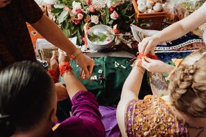 Red String Being Tyed Around Couples' Wrists During Khmer Knot-Tying Ceremony