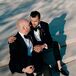 Grooms in Black-Tie Tuxes Sitting on Stairs for Wedding Portraits