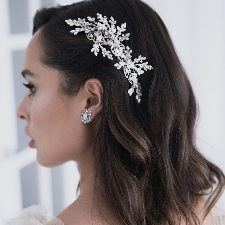 Bride wears an elegant hair comb with a floral pattern. 