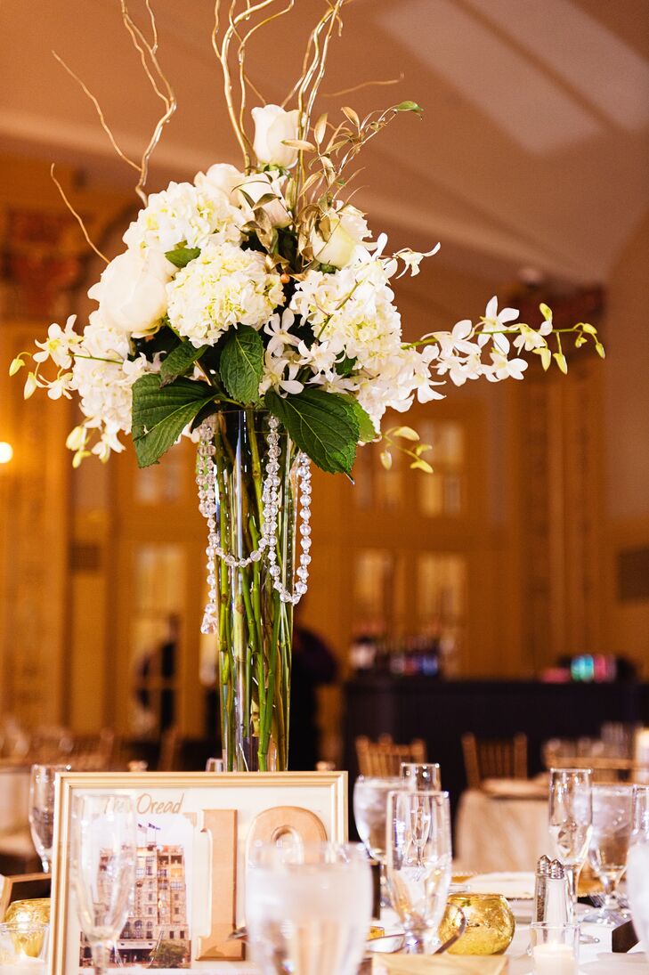 Christine and Keith decorated the reception tables with ivory hydrangeas, roses and orchids and completed the vases with gold branches and beads.